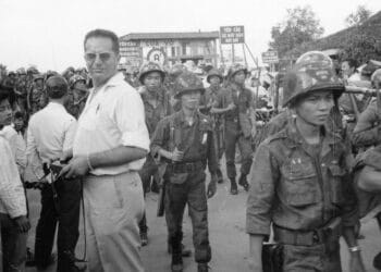 Bernard Falls stands among walking soldiers