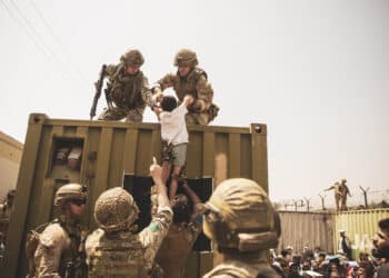 UK coalition forces, Turkish coalition forces, and U.S. Marines assist a child while evacuating Afghanistan
