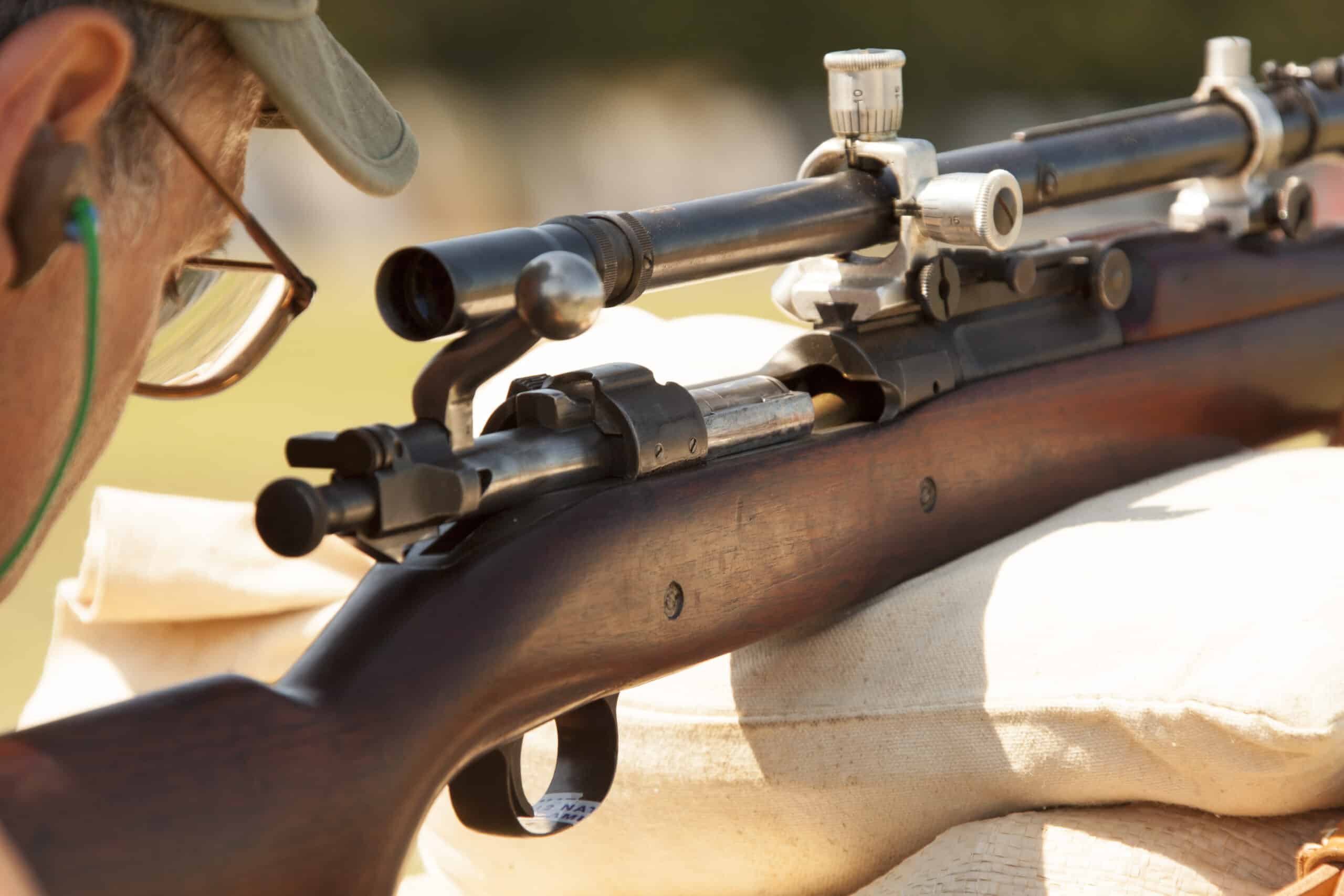 A veteran holding a vintage sniper rifle match.