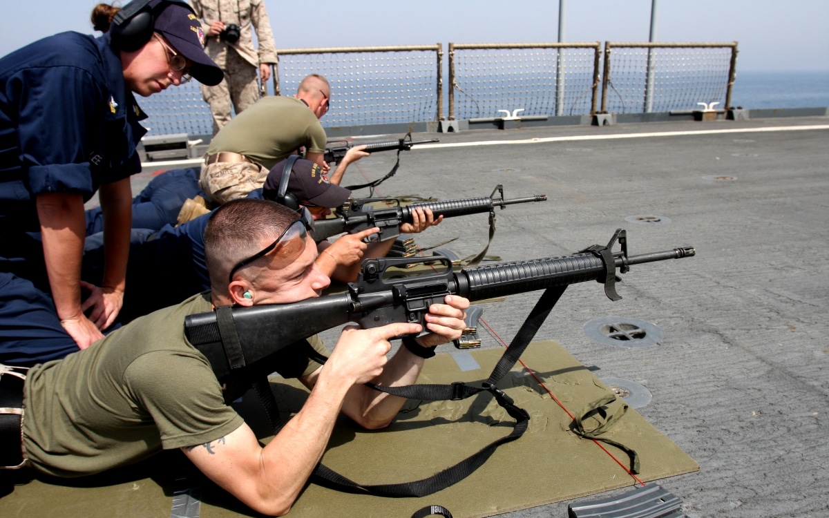24th Marine Expeditionary Unit, demonstrates the proper prone position to his shooter during a Navy small-arms
