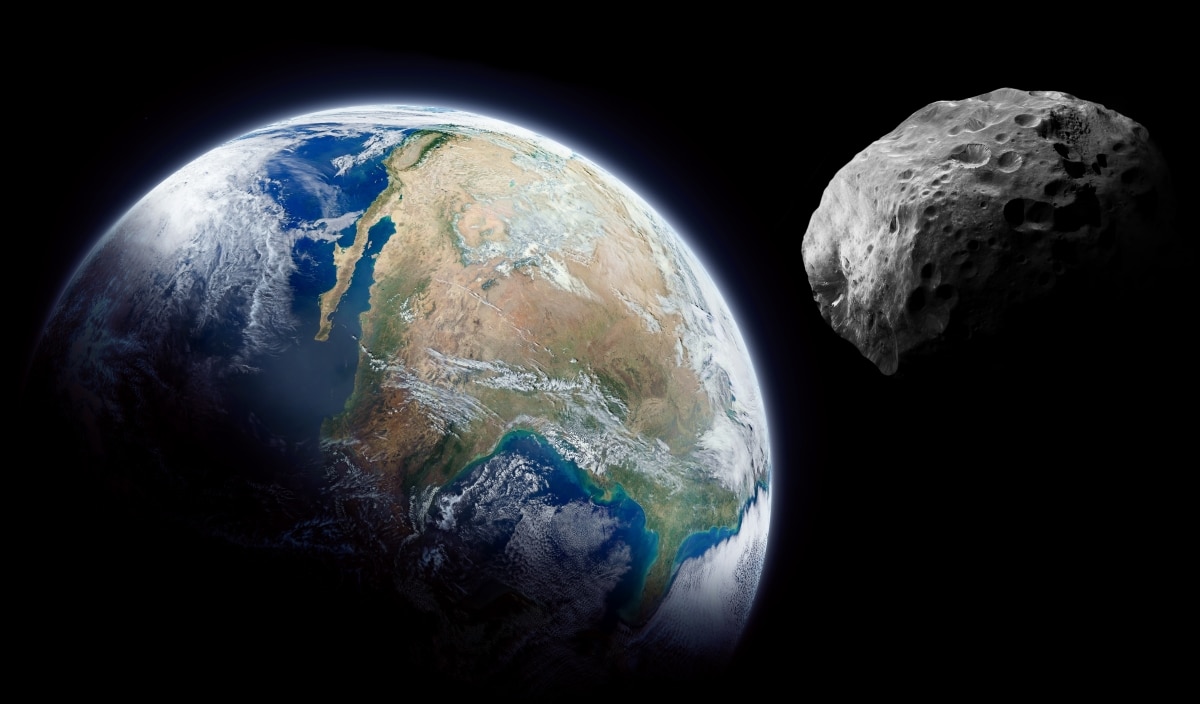 Planet Earth and big asteroid in the space. Dark background. Elements of this image furnished by NASA