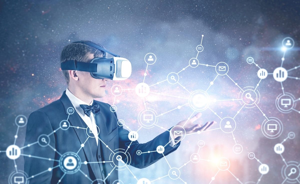 Side view of a fair hair businessman wearing VR glasses, a bow tie and a suit showing a network hologram in a city sky