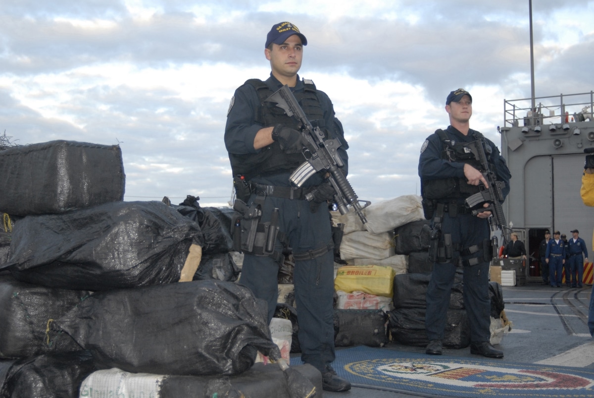 JACKSONVILLE, Fla. (Sep/Dec, 2006) -- Petty Officer 2nd Class Alexis Colon (foreground) and Petty Officer 1st Class Ryan Patterson from Coast Guard Tactical Law Enforcement Team South in Miami stand guard over several tons of cocaine