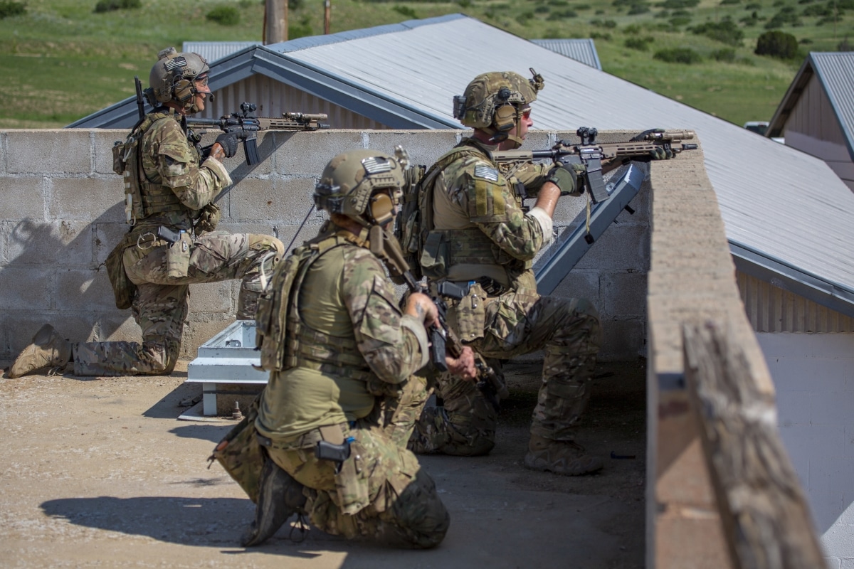 A team of Green Berets assigned to 10th Special Forces Group (Airborne) line the rooftops to pull security while scanning the area for the opposing forces during the Special Forces Advanced Urban Combat course