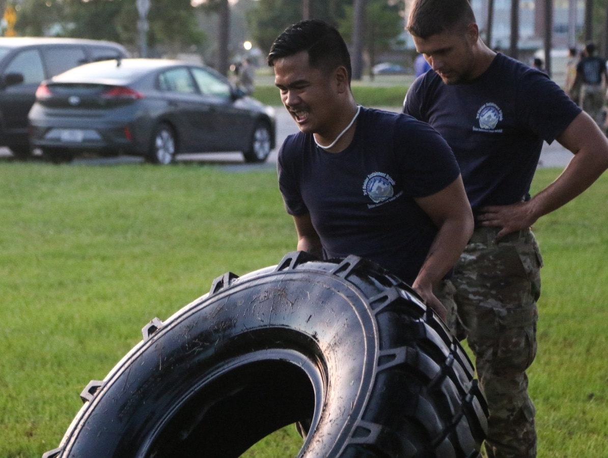 Pfc. Jeffrey Smith, a human resources specialist with the 90th Human Resources Company, 3rd Division Sustainment Brigade, 3rd Infantry Division, flips a tire during a physical fitness competition