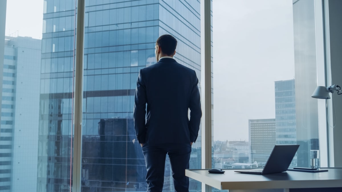 Back View of the Thoughtful Businessman wearing a Suit Standing in His Office