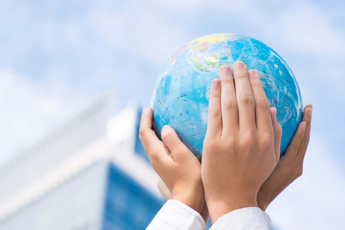Cropped image of the leaders of the company holding a globe miniature in hands in the sign of togetherness