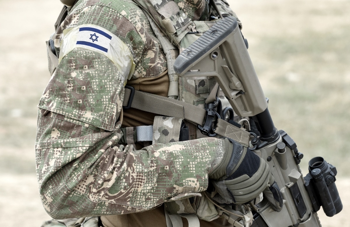 Soldier with assault rifle and flag of Israel on military uniform. Collage.