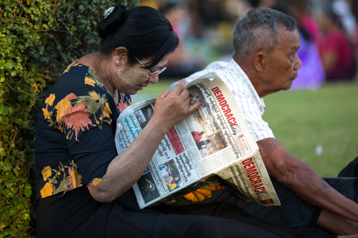 YANGON, MYANMAR - JANUARY 4, 2016: Unidentified woman reading newspaper in the park in Yangon, Myanmar