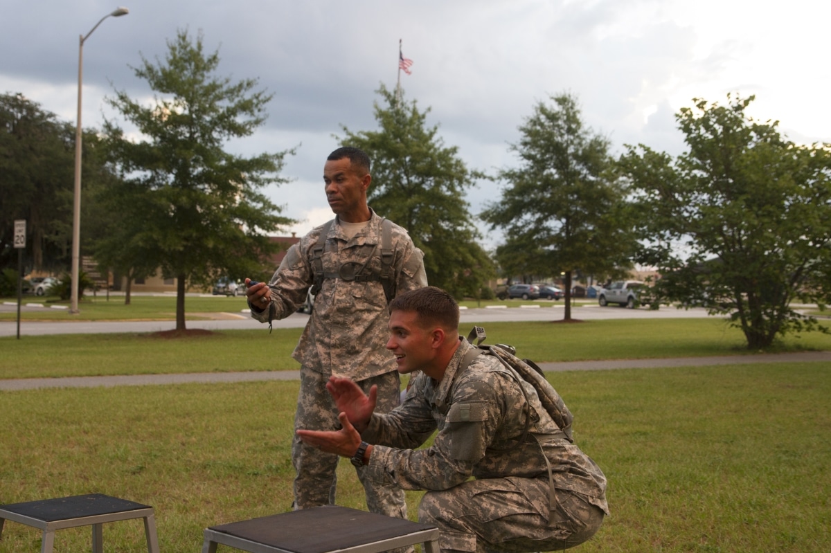 The command team from Headquarters and Headquarters Company, 3rd Combat Aviation Brigade, Capt. Jay Berger and 1st Sgt. Siamrath Kumnog watch as teams compete in commander’s cup physical training July 31 on Hunter Army Airfield.