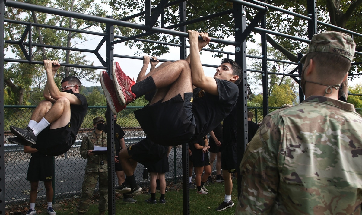 Maj. Nathaniel Stickney (right), an instructor in the Department of Electrical Engineering and Computer Science, counts the amount of leg tucks a cadet performs during the Leg Tuck portion of the Army Combat Fitness Test.
