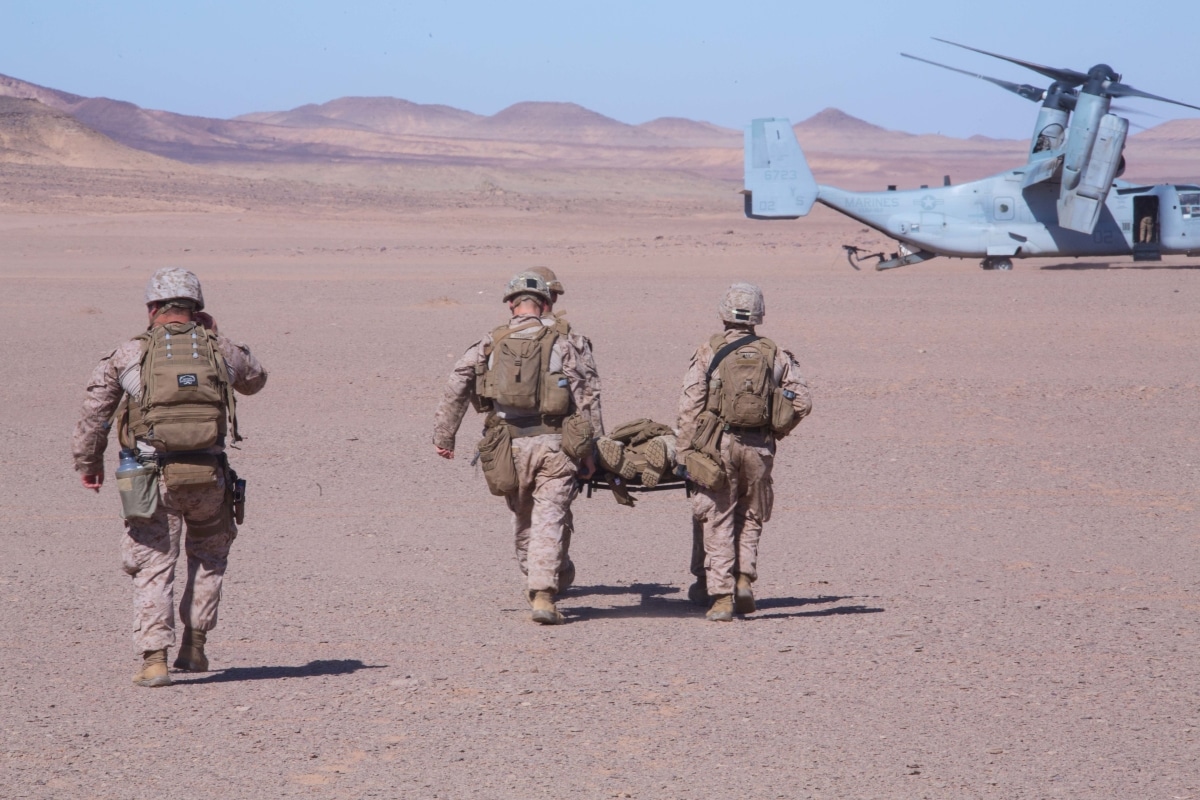 Marines and a Sailor with the 24th Marine Expeditionary Unit (MEU) carry a simulated patient to an MV-22B Osprey for medical evacuation during casualty response training as part of a theater amphibious combat rehearsal