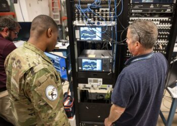 U.S. Space Force Capt. Terry Lindsey, 25th Space Range Squadron training flight commander, left, and James Vise, 25th SRS range technician, right, operate a spectrum analyzer during a CRIMSON SKIES exercise near Peterson Space Force Base