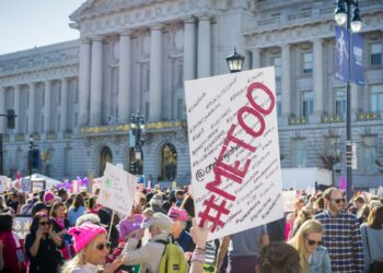 January 20, 2018 San Francisco / CA / USA - "Me too" sign raised high by a Women's March participant; the City Hall building in the background