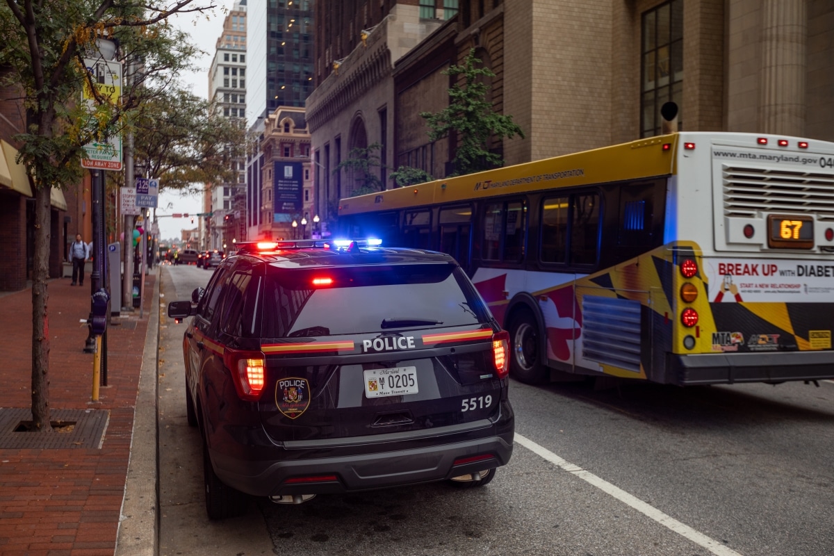 BALTIMORE, MARYLAND - OCTOBER 03, 2019: Baltimore Police Vehicle with Flashing Lights On. Cityscape in Background.