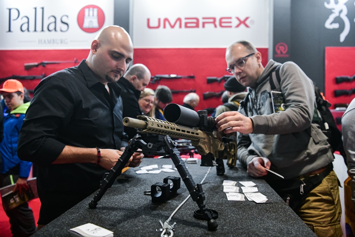 Vicenza, Italy - February 8, 2020: An exhibor shows to a visitor a weapon on display at Hit Show 2020, trade fair show dedicated to hunting, target sports and outdoor