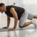 Sporty African American Man Doing Running Plank Exercise At Home. Side View Of Athletic Guy Training In Living Room. Male Fitness Workout And Bodybuilding. Sport Motivation Concept. Panorama