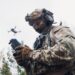 Military soldier controls drone for reconnaissance operation of enemy positions. Concept using quadrocopters in smart war.
