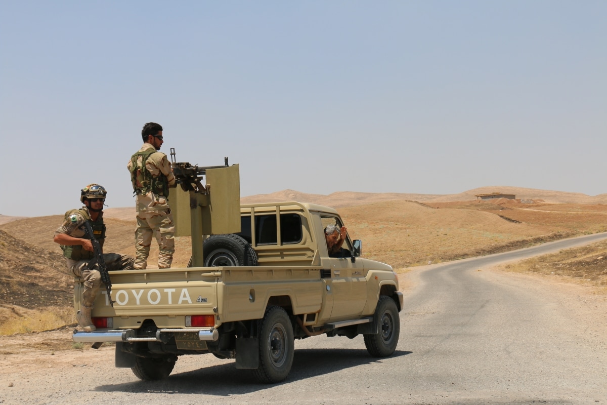 BASHIK FRONTLINE, KURDISTAN, IRAQ - 2015 JULY 25 - Two unidentified kurdish (peshmerga) fighters in back of truck at BASHIK (bashik) base 25km from ISIS controlled Mosul.