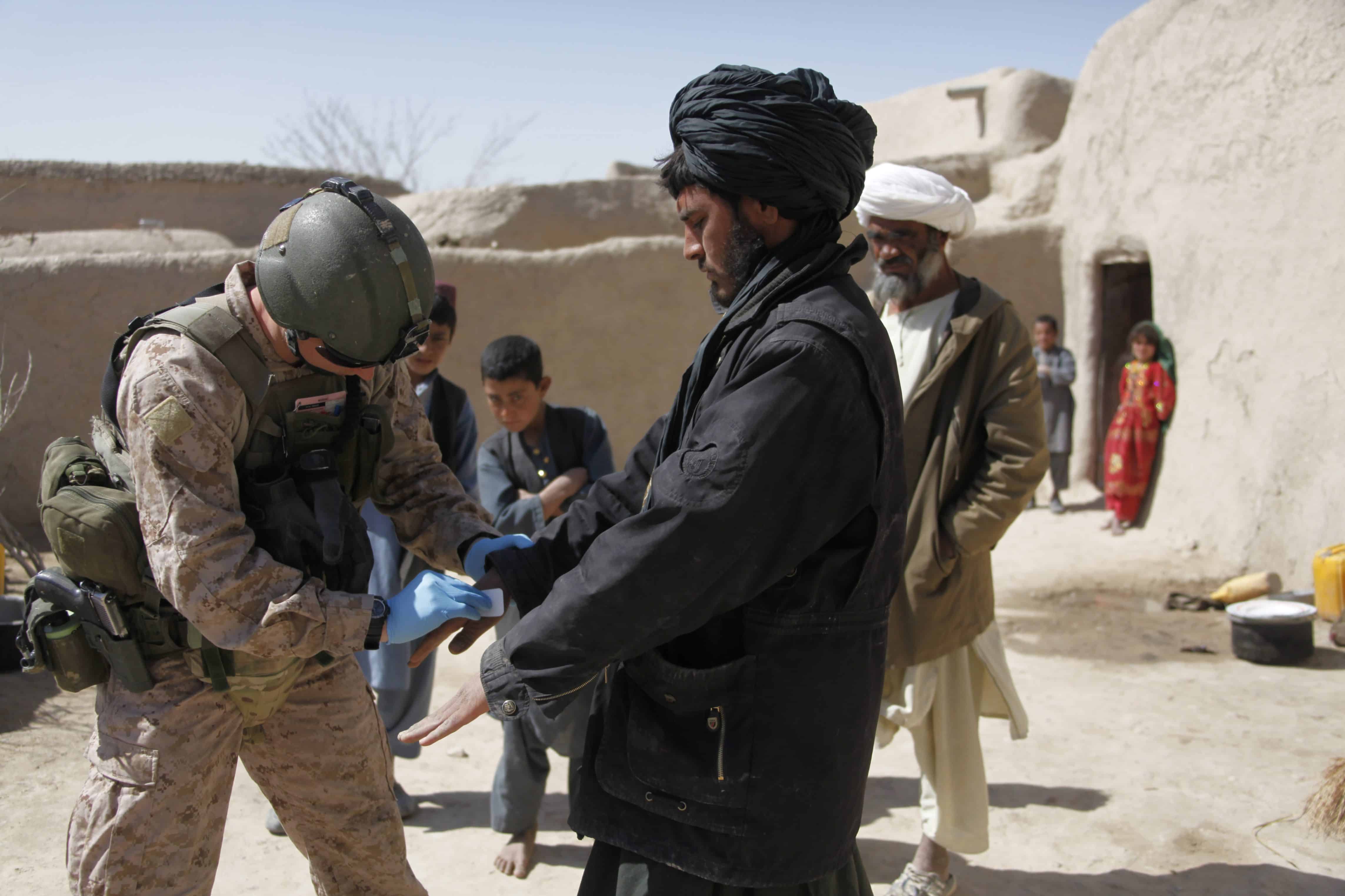 Kajaki, Afghanistan - March 01, 2012: British Royal Marine documents Afghan nationals fingerprints and photographs for a terrorist data base.