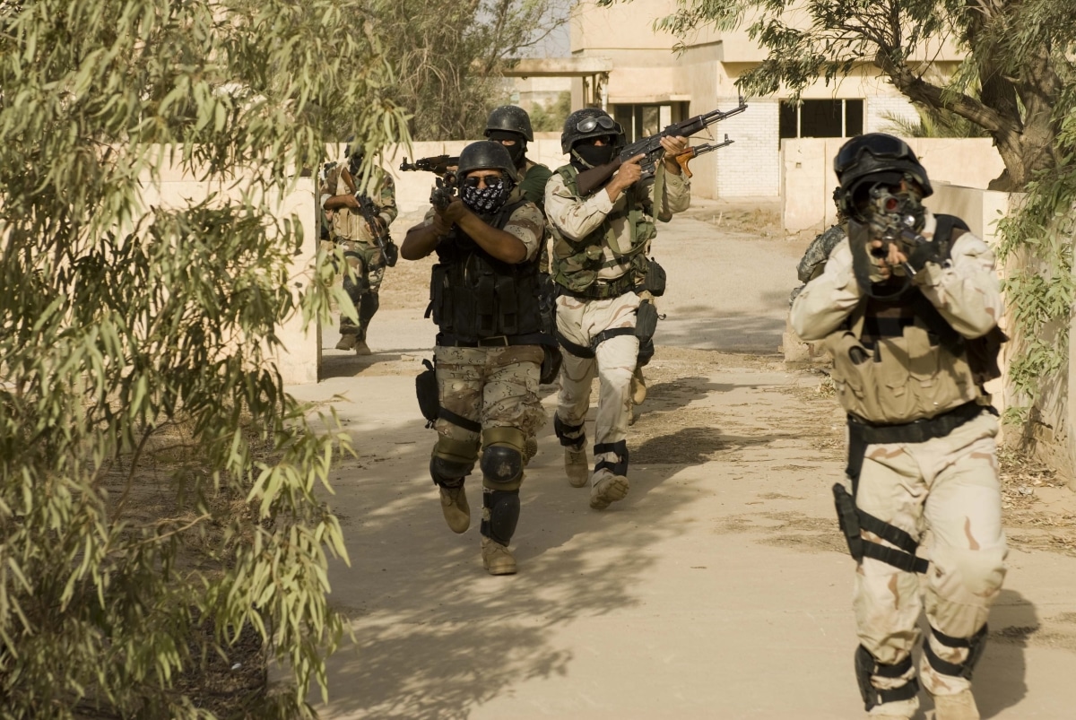 Iraqi army scouts approach a house to clear it during a training exercise designed to simulate a raid and pursuit of a terrorist target in an urban environment on Forward Operating Base Delta, Iraq, July 15.