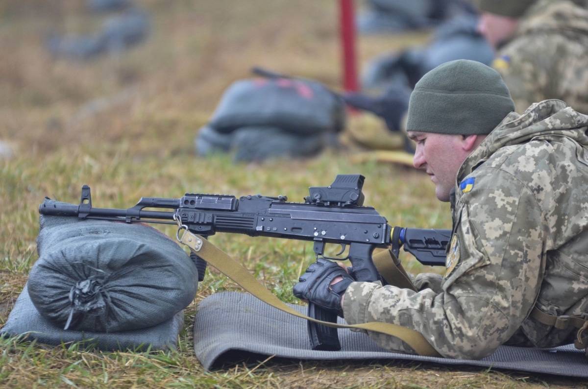 A soldier with the Ukrainian army inserts a magazine into a Kalashnikov modernized automatic rifle or AKM