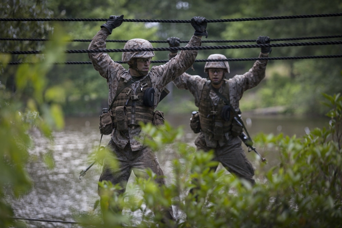 Officer candidates cross a two-rope bridge during the Combat Course at Marine Corps Officer Candidates School aboard Marine Corps Base