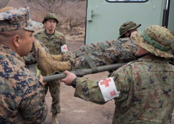 U.S. Navy corpsmen with the 31st Marine Expeditionary Unit and soldiers with the 1st Amphibious Rapid Deployment Regiment, Japan Ground Self-Defense Force, lift a stretcher with a simulated casualty on it at Hijudai