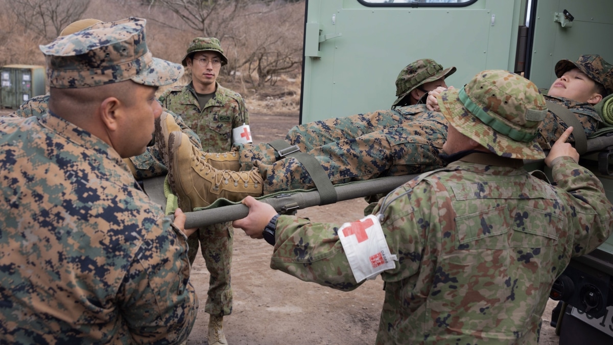 U.S. Navy corpsmen with the 31st Marine Expeditionary Unit and soldiers with the 1st Amphibious Rapid Deployment Regiment, Japan Ground Self-Defense Force, lift a stretcher with a simulated casualty on it at Hijudai