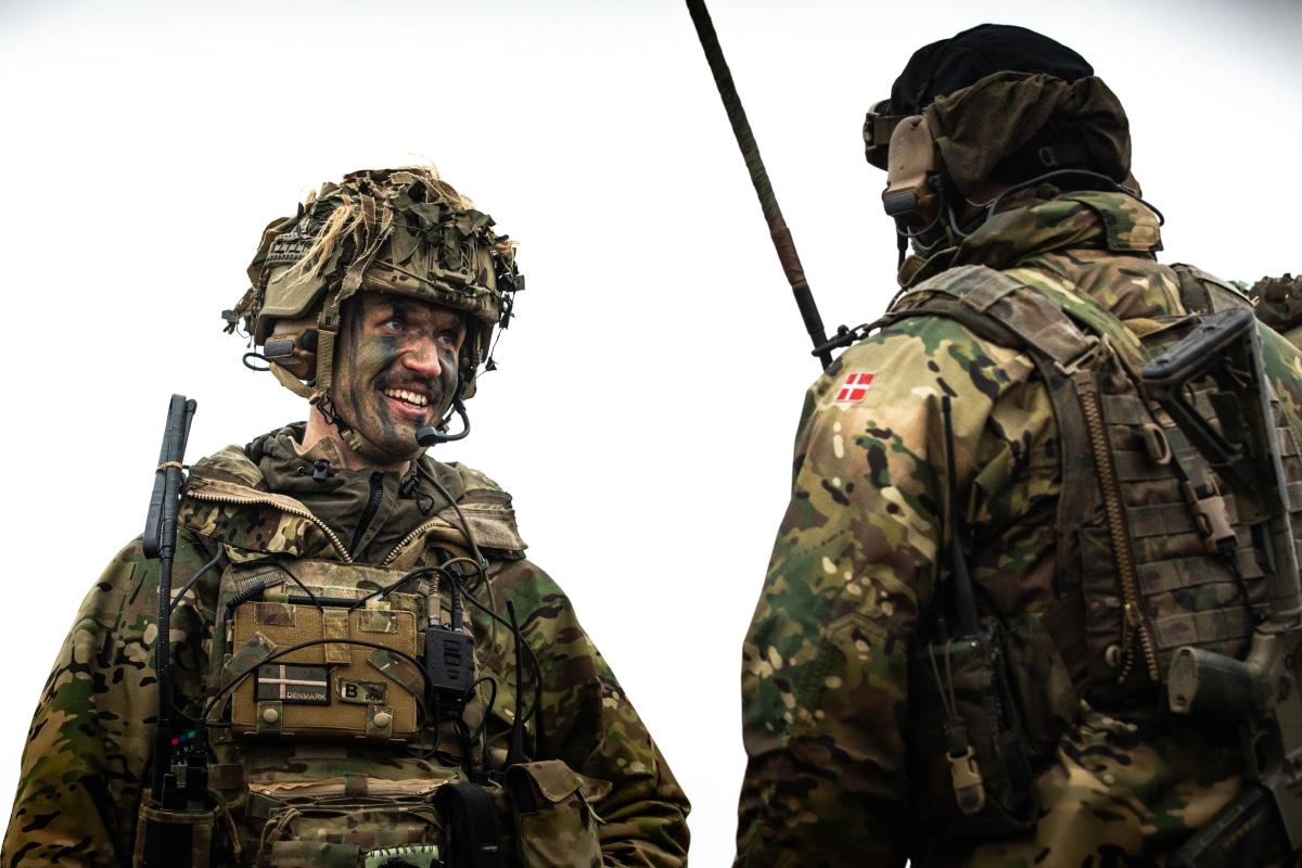 Danish soldiers talk during a live-fire demonstration March 30, 2023, for distinguished visitors as part of exercise Dynamic Front held at Oksbol, Denmark. Dynamic Front is a U.S. Army Europe