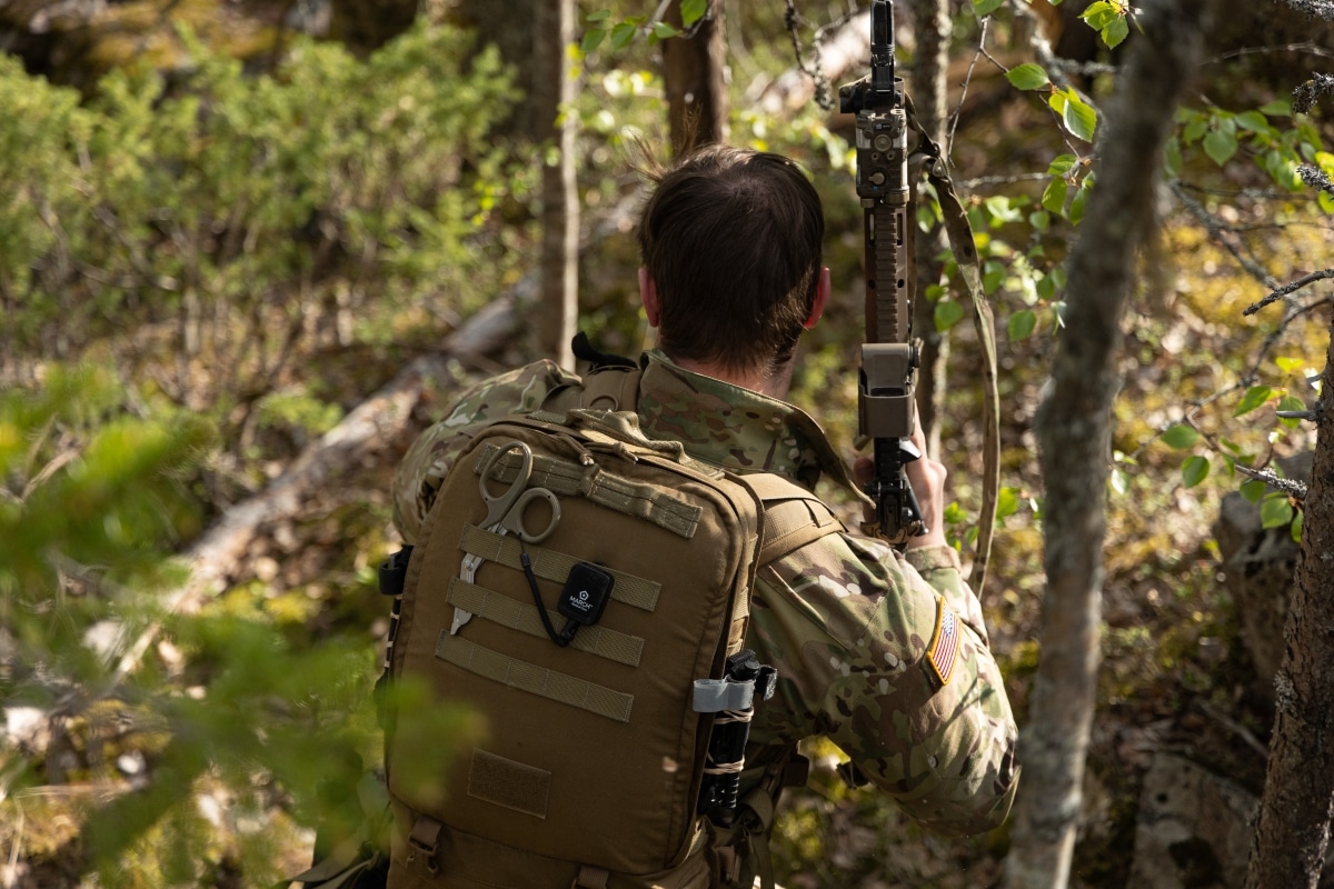 A U.S. Army Special Forces medical sergeant with 10th Special Forces Group (Airborne) maneuvers through a taiga forest to link up with friendly forces in Kalix