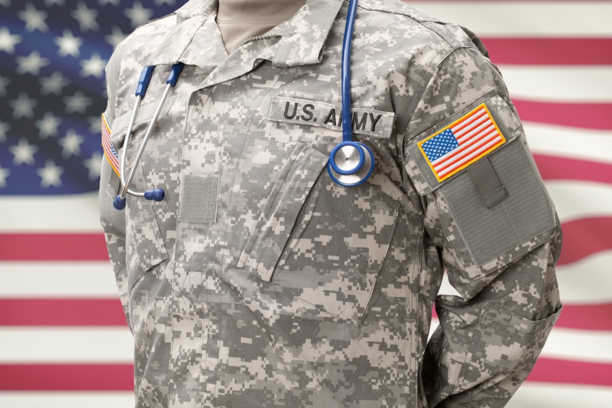 USA Army doctor with stethoscope over his neck and USA flag on background
