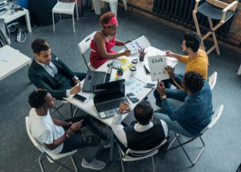 A team of young people confers and discusses the growth of investment at work. Business