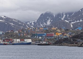 Sisimiut, Greenland - July 1st 2018: The harbour area of town with back drop of mountains. Boats are an essential form of travel in Greenland. Photos taken on a tour of Greenland's west coast.