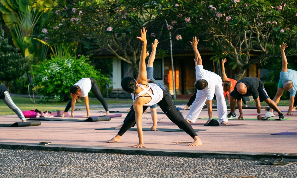 Denpasar, Bali, Indonesia - 19 September 2019: Yoga teacher do the yoga pose in a yoga group session retreat.