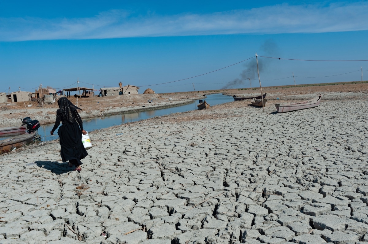 Al-Chibayish, Iraq. November 1st 2018 A Marsh Arab woman collecting water in the parched wetlands of the Central Marshes of southern Iraq