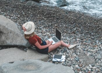 Remote work.Girl freelancer works remotely on the seashore.workation, remote work,WFVH,Van Life vibes work from vacation home,work travel,remotely work.Travelling