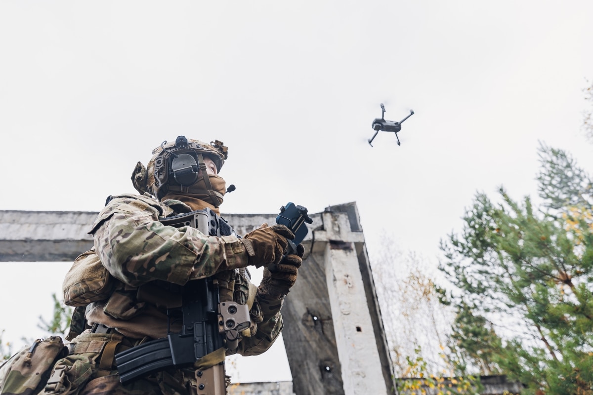 Military soldier controls drone for reconnaissance operation of enemy positions. Concept using robot in smart war.