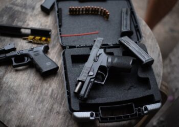 Dusit Bangkok Thailand 26 December 2022: Sig Sauer P320 pistol on a wooden table New alternatives for the Thai police.