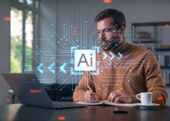 Thoughtful businessman programmer in casual wear typing on laptop at office workplace.
