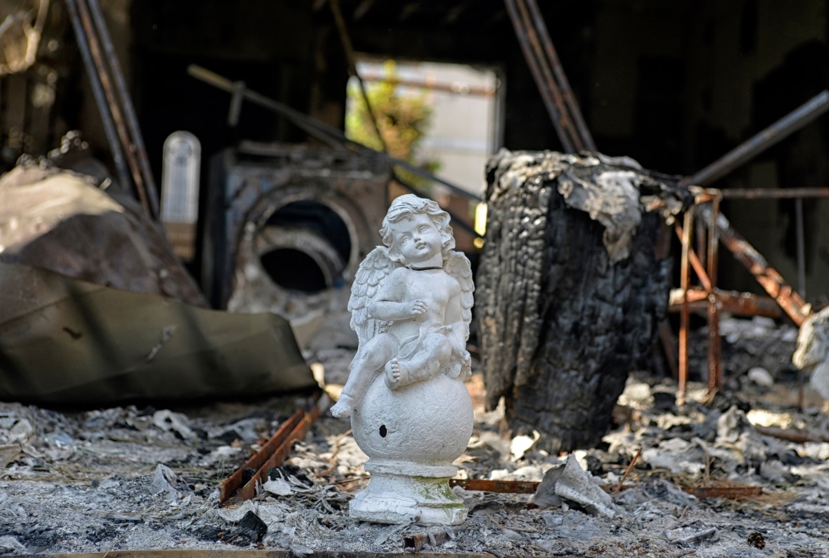 The guardian angel statue near the burned house, after artillery shelling by the Russian army.
