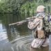 Member of Navy SEAL Team crossing the river with weapons