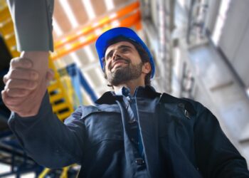 Portrait of a man giving an handshake in an industrial facility
