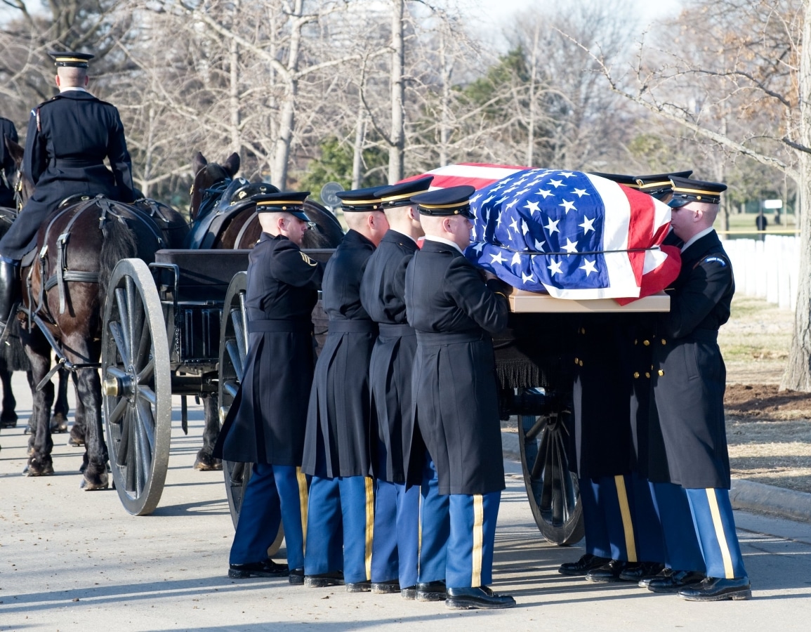 WASHINGTON - JANUARY 14: Military personnel take flag-covered casket from caisson for full honors funeral at Arlington Cemetery