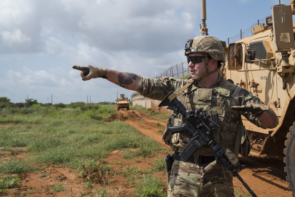 U.S. Army Sgt. Don Baldwin, infantryman, assigned to Task Force Guardian, 41st Infantry Brigade Combat Team (IBCT), 1-186th Infantry Battalion, Oregon National Guard, points to the horizon while explaining items of interest to look out for during a security patrol in Somalia