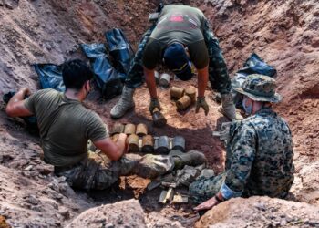 U.S. Air Force Staff Sgt. Justin Campos, left, an explosive ordnance disposal (EOD) technician with 18th Civil Engineer Squadron, Sgt. Maj. 1st Class Thankakorn Ngammeun, center, a deminer with Humanitarian Mine Action Unit 1, and U.S. Marine Corps Sgt. Aaron Pryor, an EOD Technician with EOD Company, 9th Engineer Support Battalion