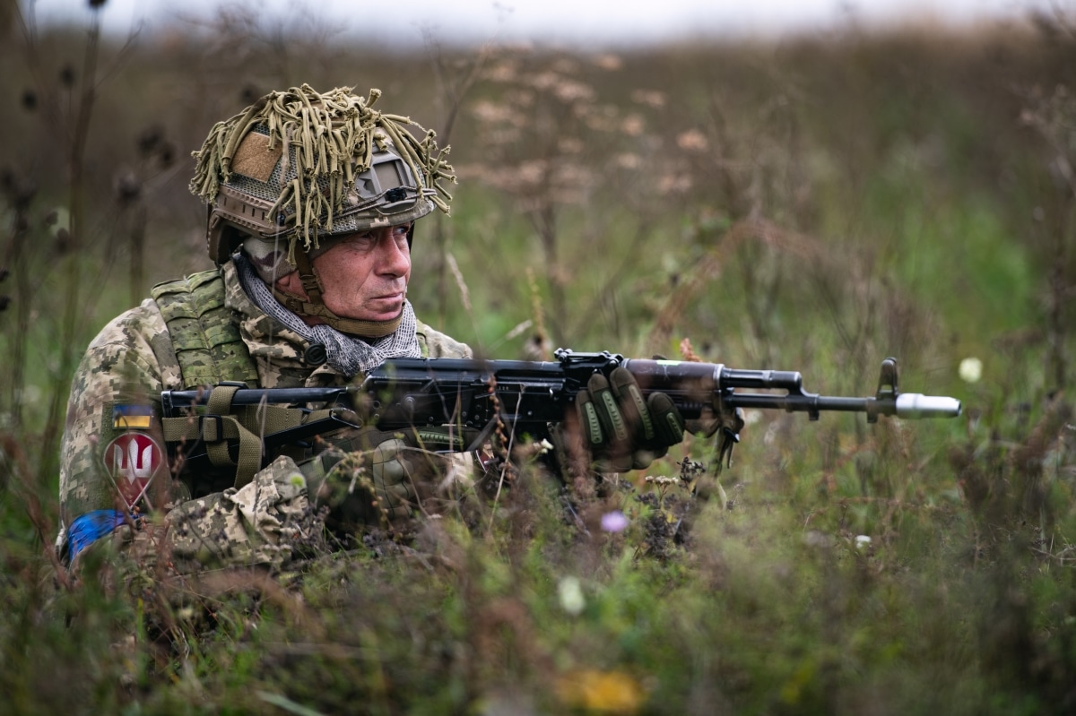 A Ukrainian paratrooper assigned to the Lithuanian - Polish - Ukrainian Brigade establishes sector security on a drop zone alongside paratroopers from 1st Battalion, 503rd Parachute Infantry Regiment after conducting a joint airborne operation.