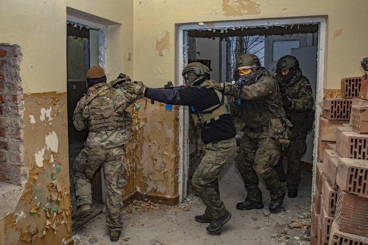 A team of Polish 1st Territorial Defence Brigade and U.S. Army National Guard soldiers clear a room during a training exercise in Sejny, Poland on November