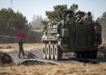 A Polish Land Forces Soldier guides U.S. Soldiers assigned to 1st Battalion, 185th Infantry Regiment across a bridge during a wet gap crossing at Bull Run 2022, a show-of-force exercise at Siemianowka Reservoir, Bondary, Poland, March 25, 2022. (U.S. Army photo by Spc. Justin Leva)