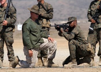 Sgt. Ryan Salinas, primary marksmanship instructor, Weapons Company, Weapons and Field Training Battalion, helps a recruit of Company F, 2nd Recruit Training Battalion, with his kneeling position while snapping in Oct. 2 at Edson Range aboard Marine Corps Base Camp Pendleton. Recruits snap in for hours, learning to be comfortable with each position before they head to the firing line the following week.